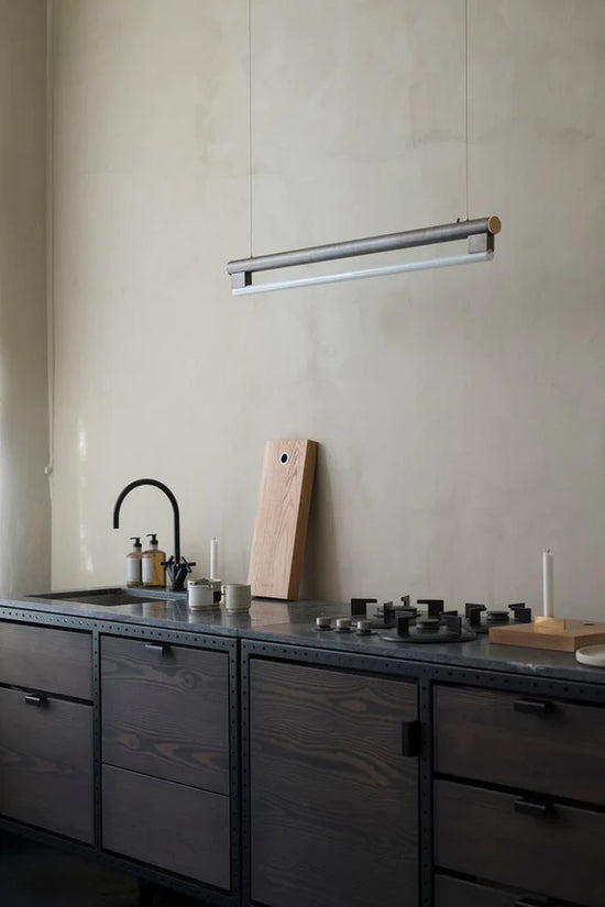 The Eiffel Pendant Lamp by FRAMA hanging above a lovely dark wooden one wall kitchen counter.