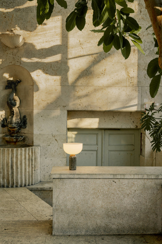 New Works portable table lamp with gris du marais marble outside on wall