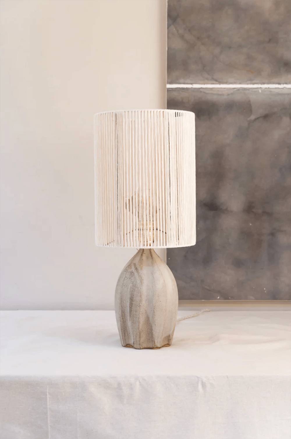 A ceramic table lamp by Grès Ceramics, handcrafted in France. The quirky hand knotted jute screen adds a bohemian feel to any interior. 