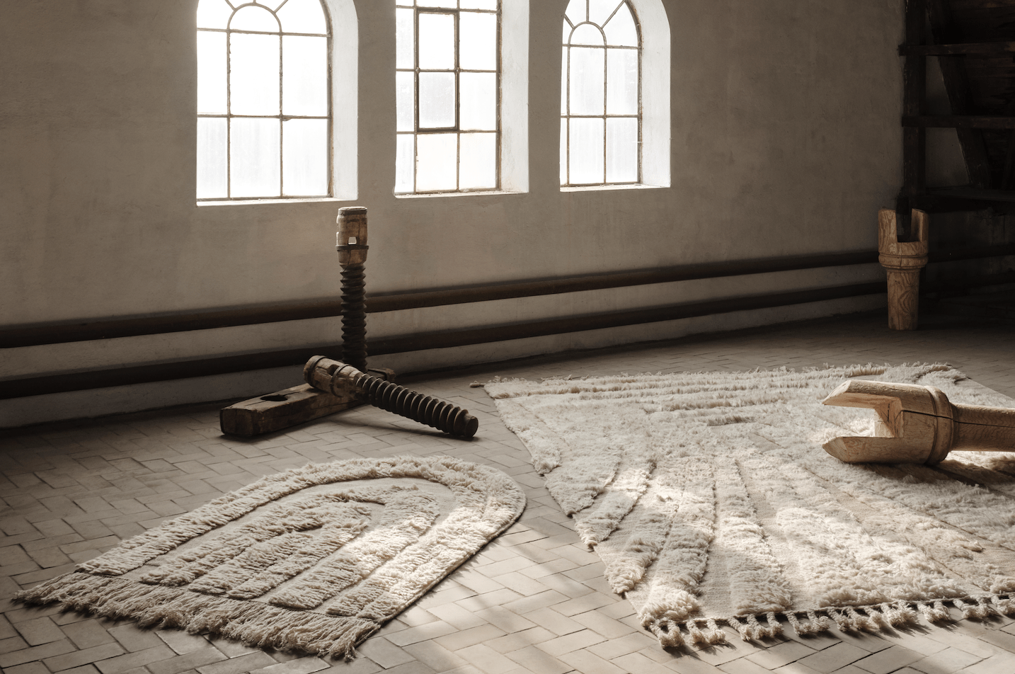 Enter The Loft - a neutral coloured room with rugs and objects in it.