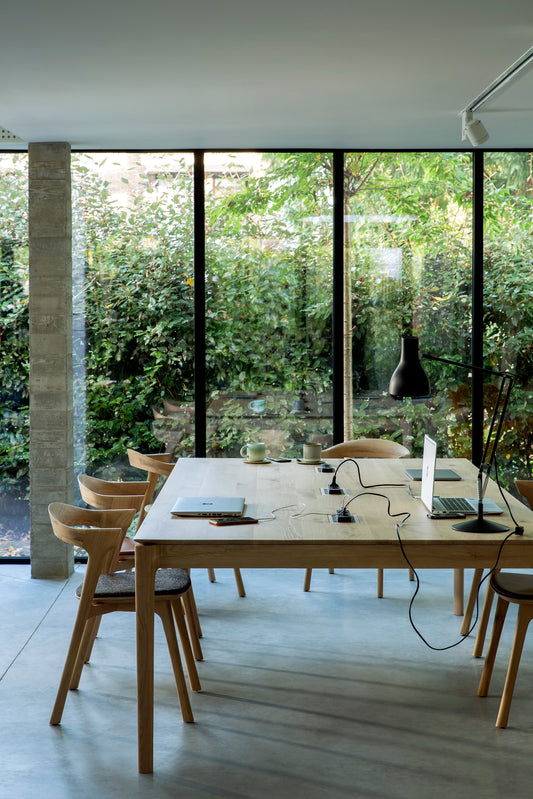 The Bok Cowork Desk by Ethnicraft in a office space, with 6 bok chairs