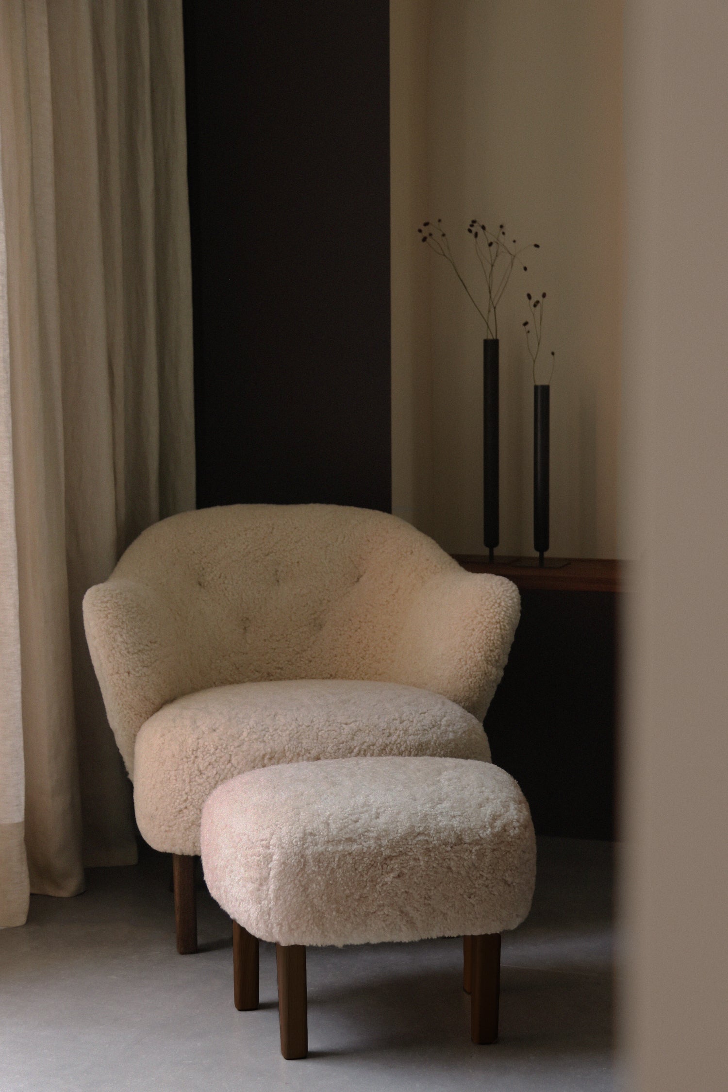 The Ingeborg Ottoman and chair in Sheepskin moonlight together. By Audo CPH.