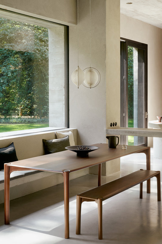 PI Dining table teak brown by ethnicraft in context setting with PI bench in dining room.