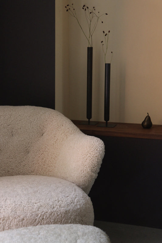 A close up of the Ingeborg Ottoman and chair Sheepskin Moonlight by Audo CPH