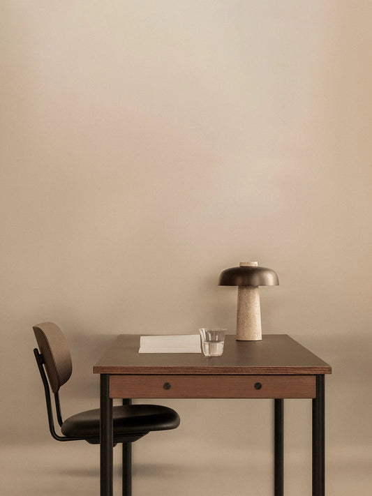 Co Task Chair Dark Stained Oak with Sierra 1001, Seat Upholstered with Black Frama by Audo Copenhagen at a desk with an table lamp from Audo Copenhagen.