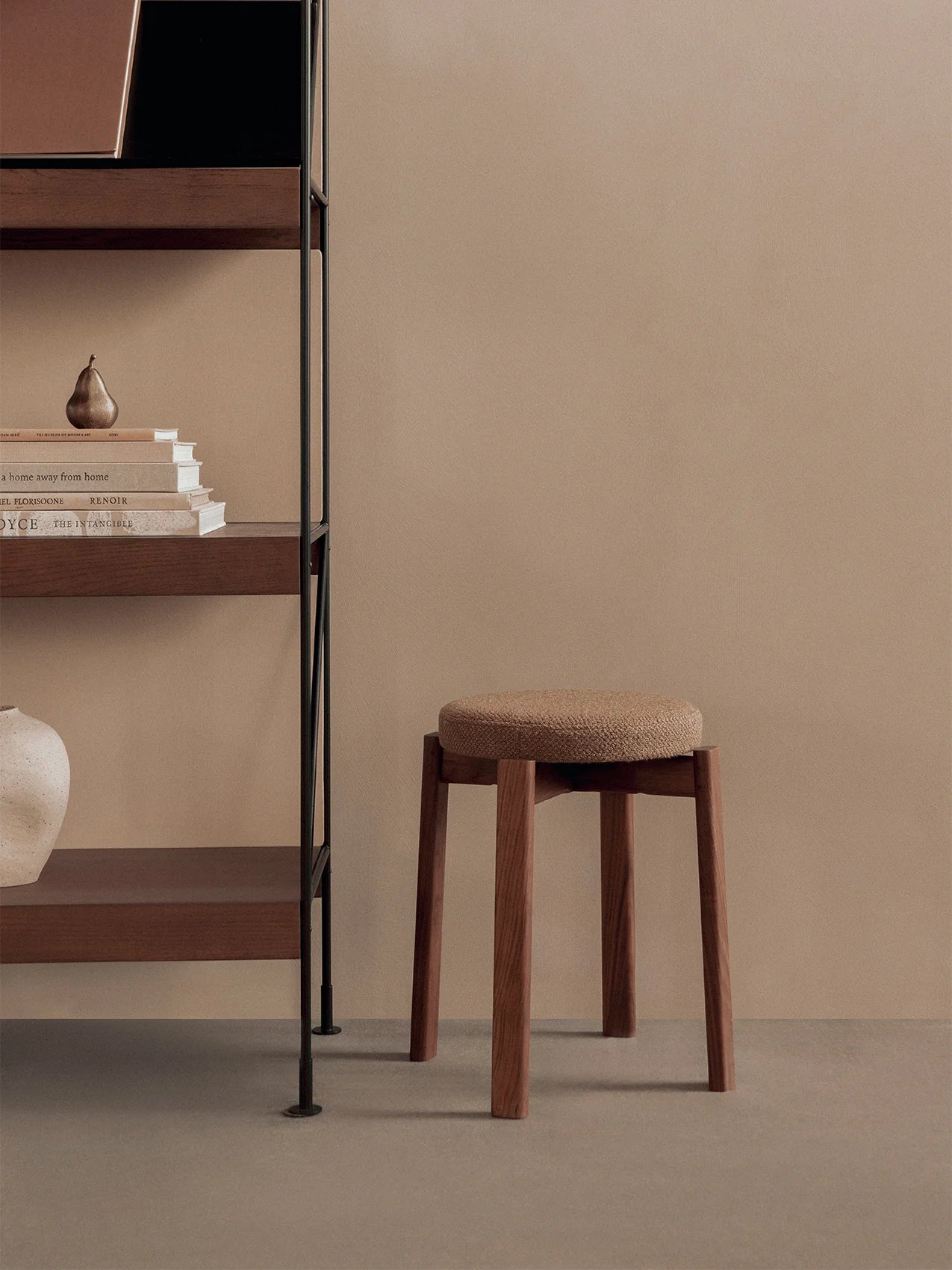 The Passage Stool Upholstered in walnut with Audo Bouclé 06, next to a cabinet from Audo.