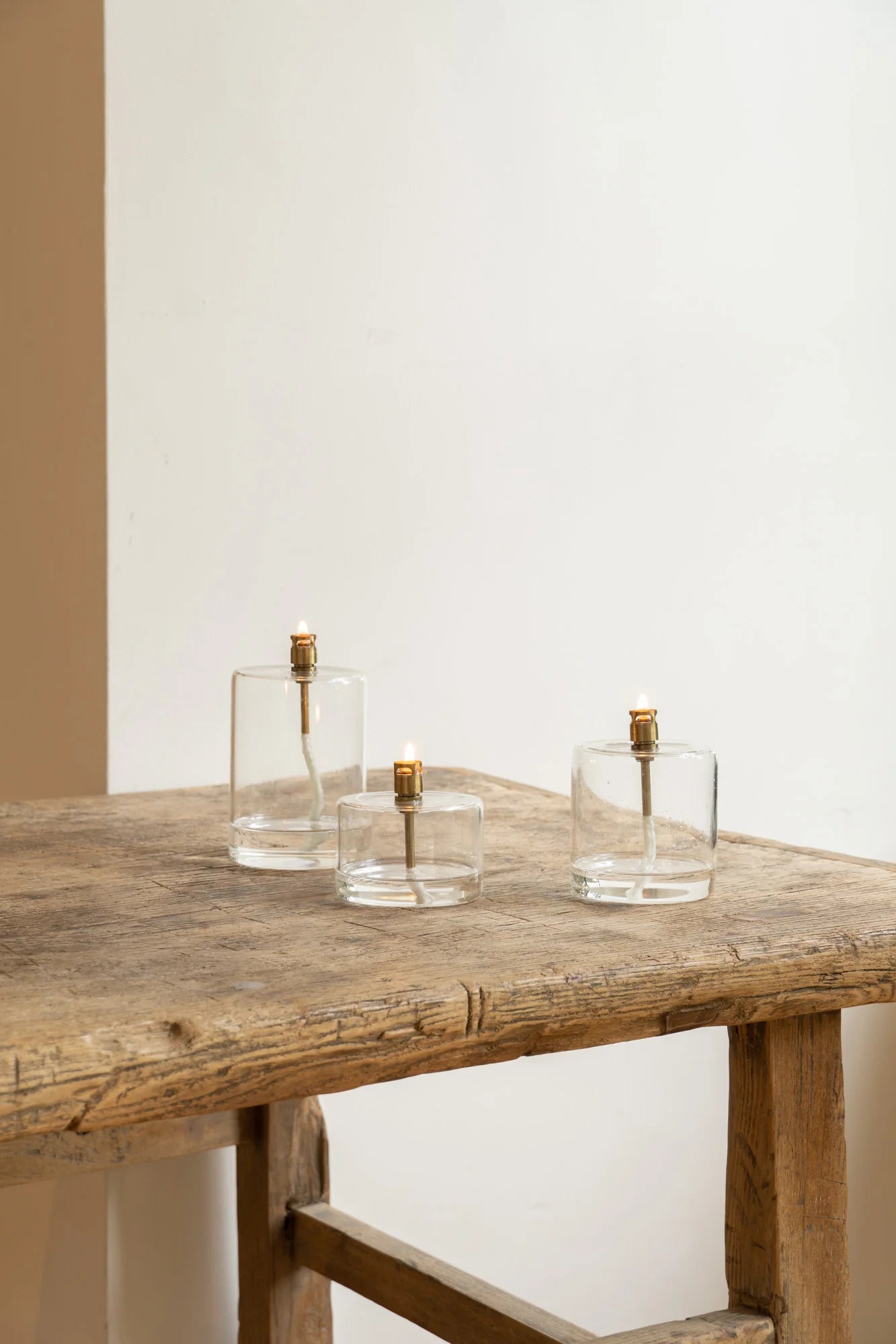 three cylinder oil lamps on table