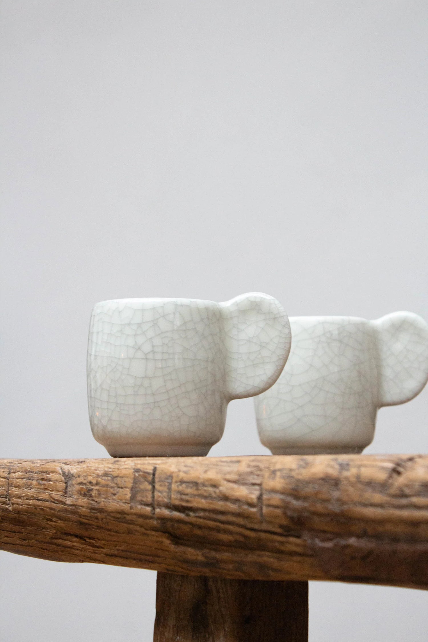 Ceramic mugs set on wooden table.