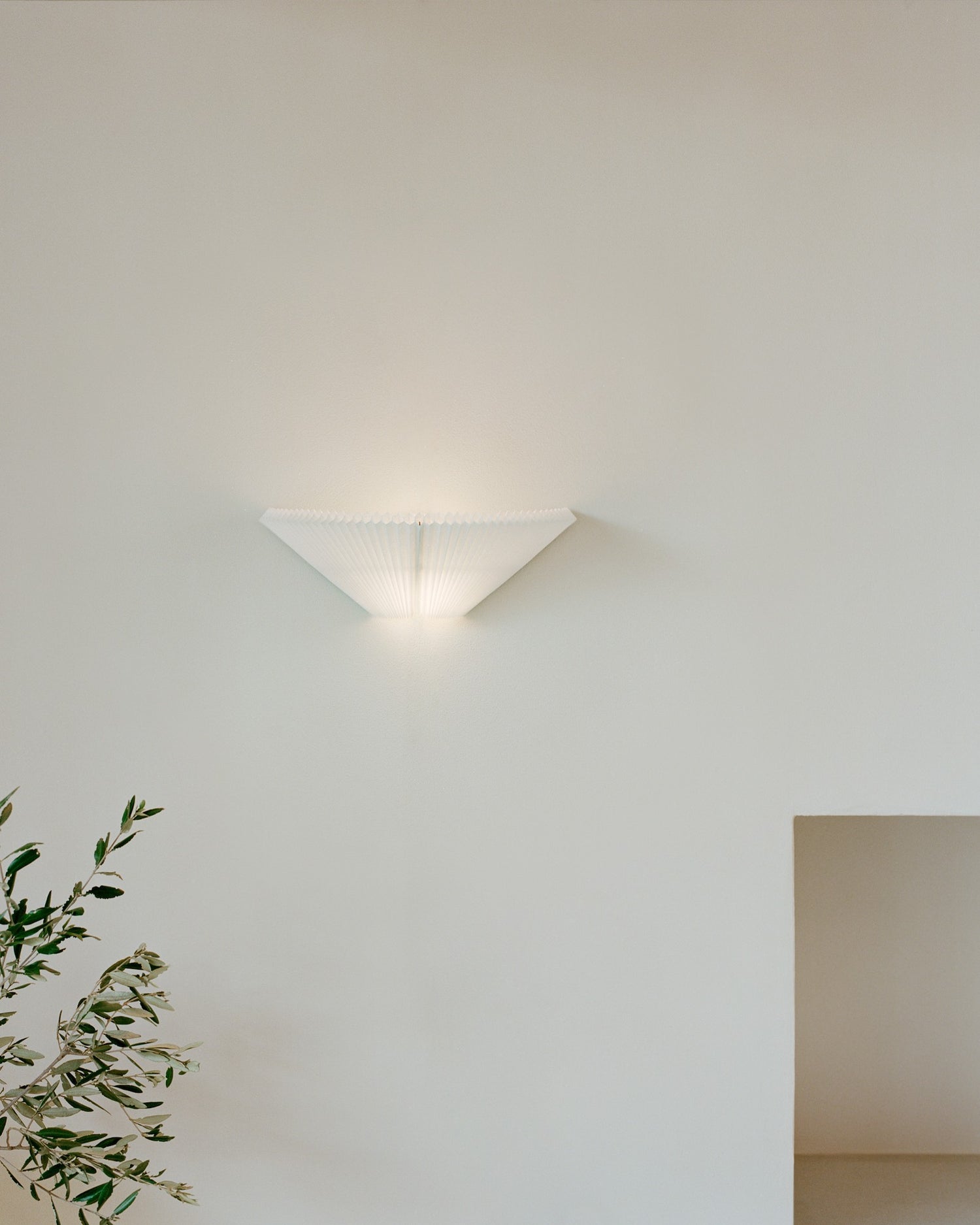 Nebra Wall Lamp by New Works, on ceiling with shade turned down, front view