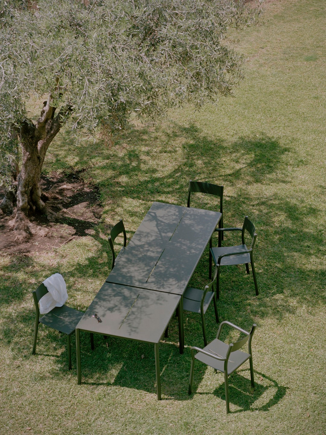 The dark green may outdoor collection with two tables and some armchairs and chairs without armrests.