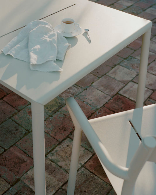 Detail shot of the new works may table and chair in light grey with espresso on it and a napkin