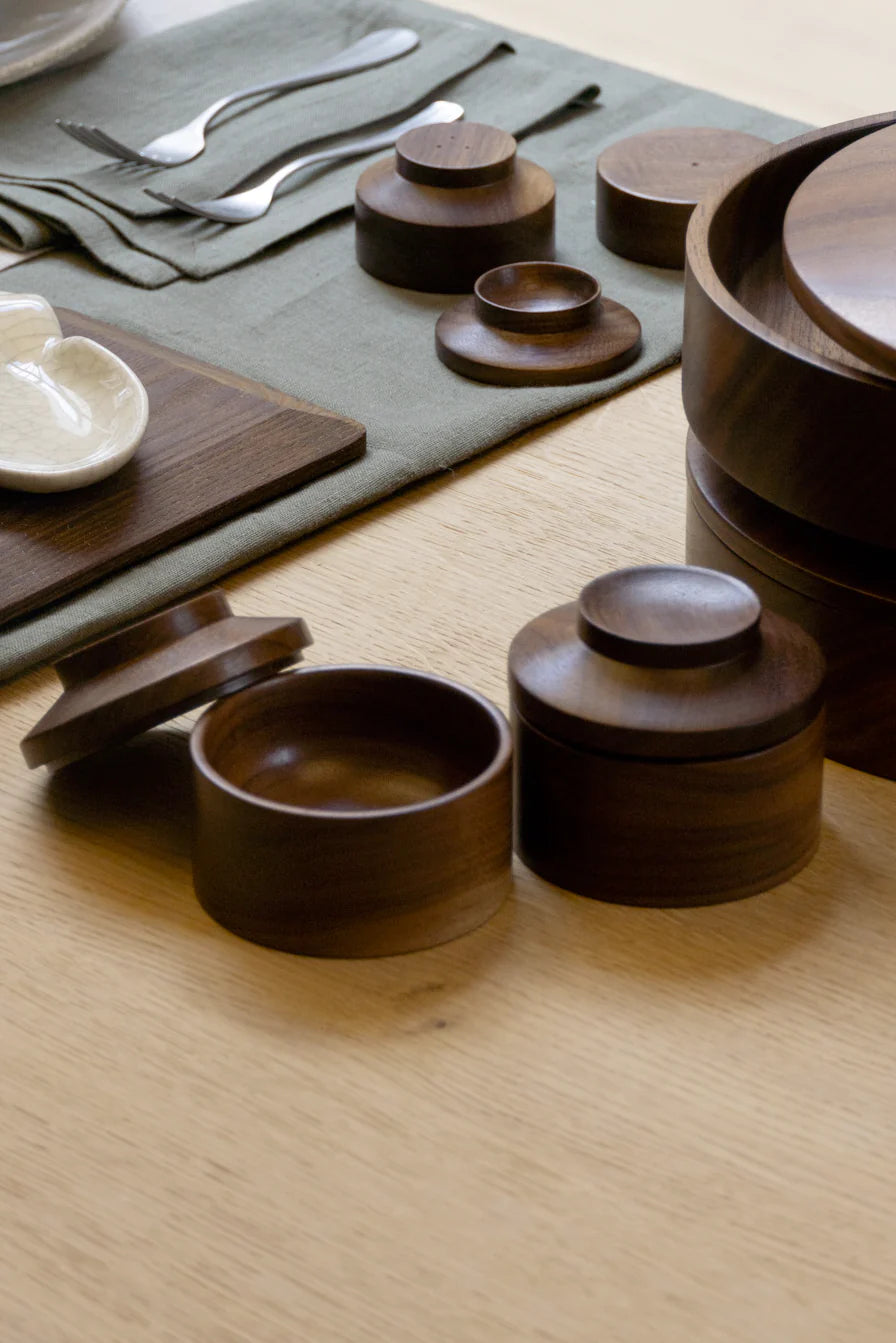 Hand crafted, dark walnut storage jars. The lid can also be used as a little plate. Repeat Stackable Little Storage Jars (set of 2) by Houtlokaal.