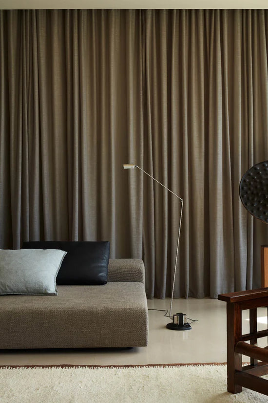 Daphine Terra Floor Lamp Brushed Nickel by Lumina set in a neutral interior design living room with modular sofa and dark neutral curtains.