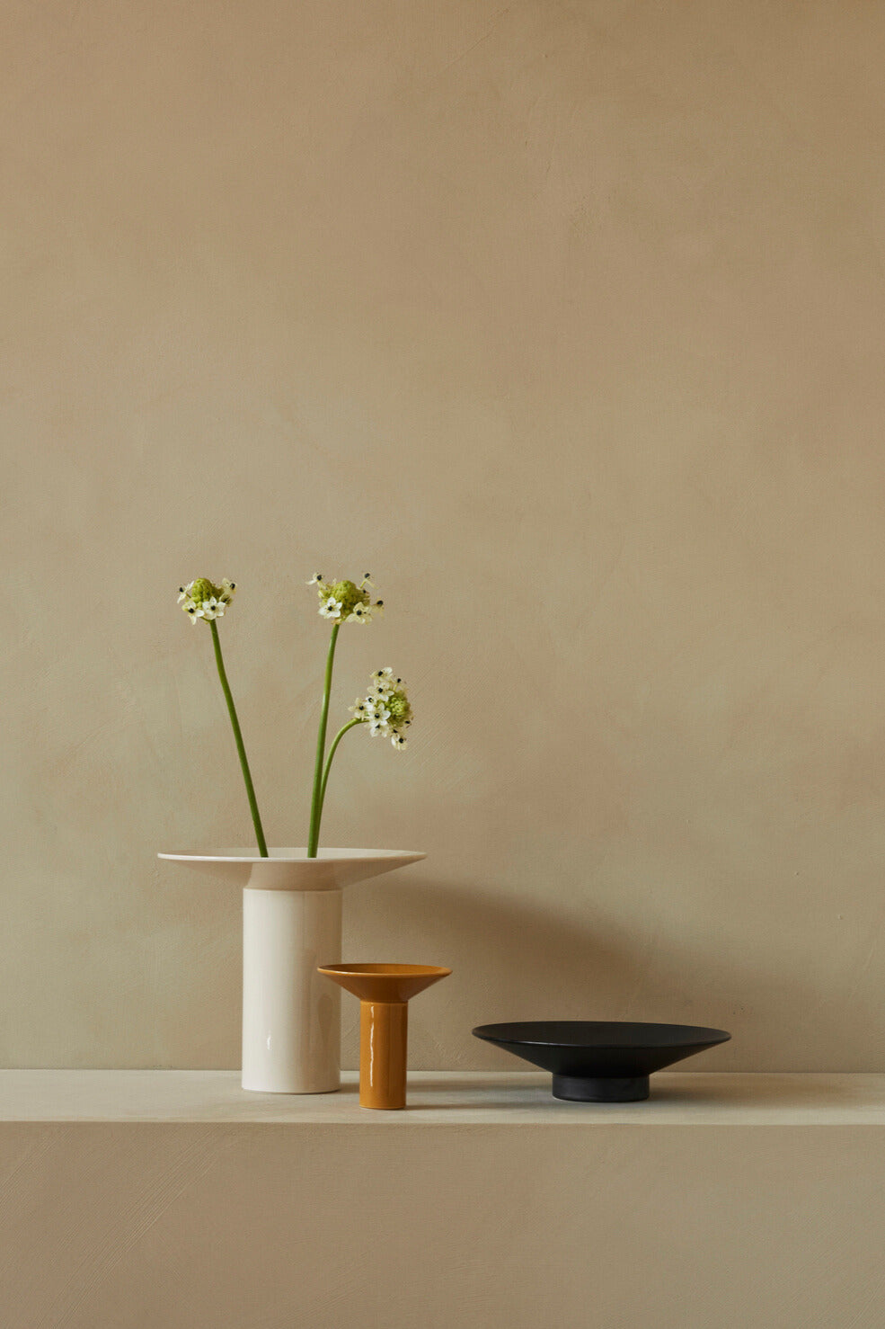 Audo Copenhagen (Menu) Hana Vases in three colors with flower arrangement against wall