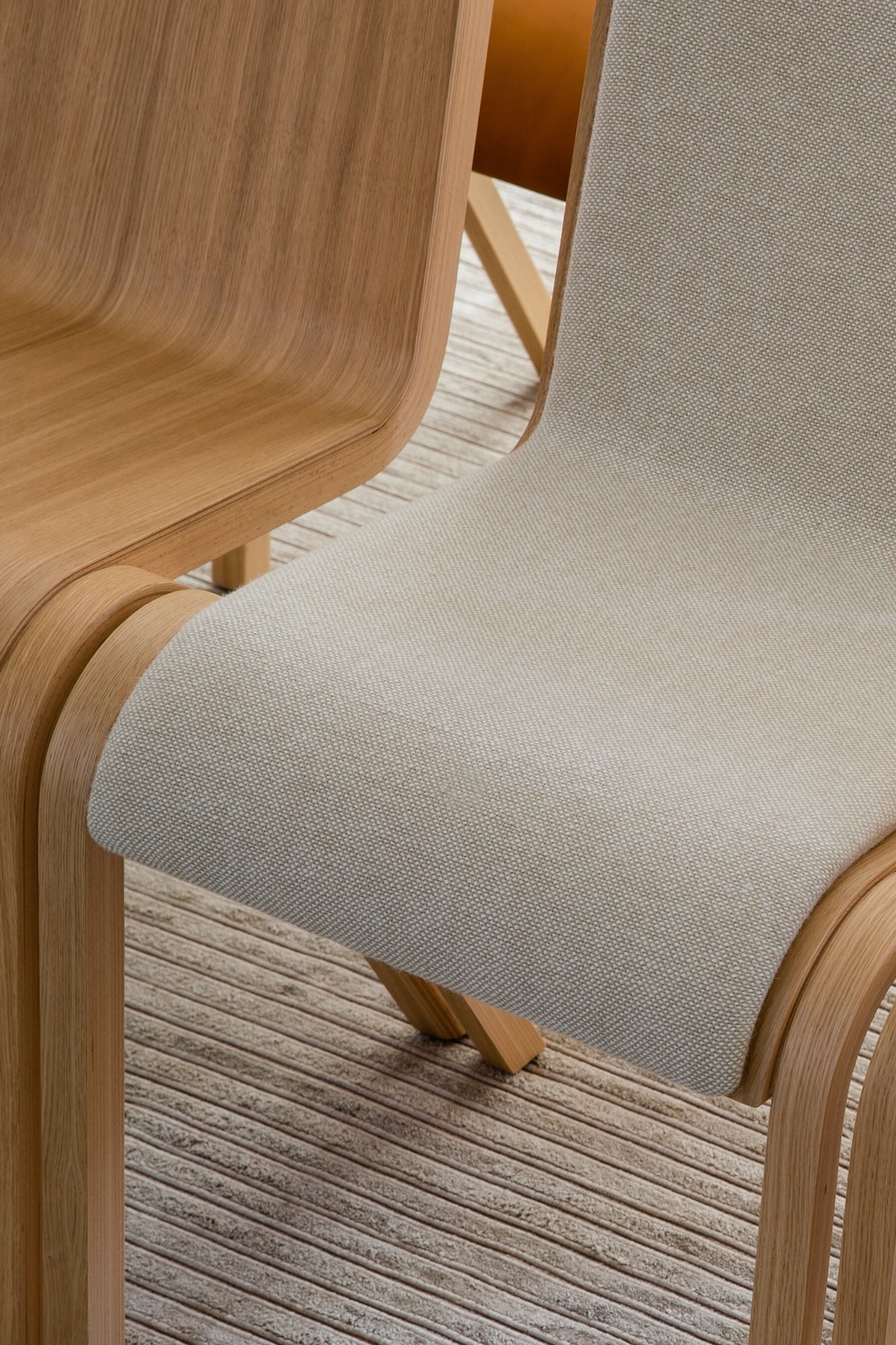 The Ready Dining Chair Front Upholstered next to an Ready Dining Chair Without Upholstery in Natural Oak by Audo Copenhagen.
