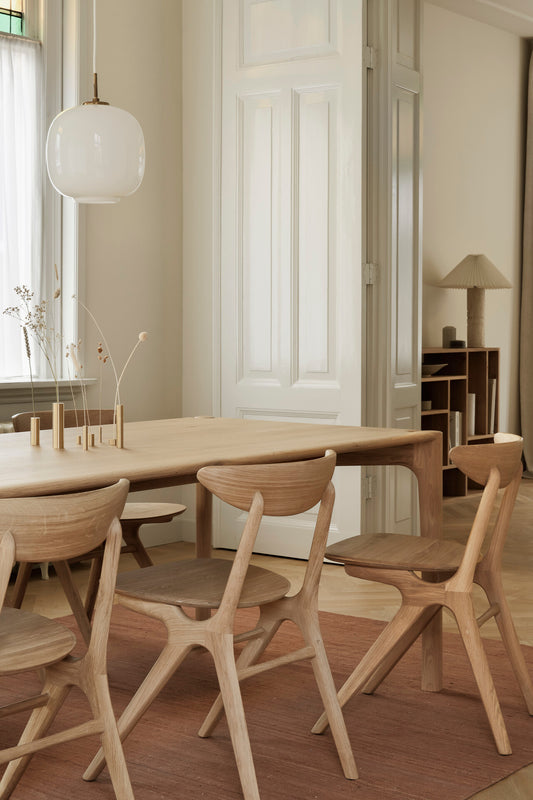 PI Table in Oak designed by ethnicraft in interior setting with dining chairs