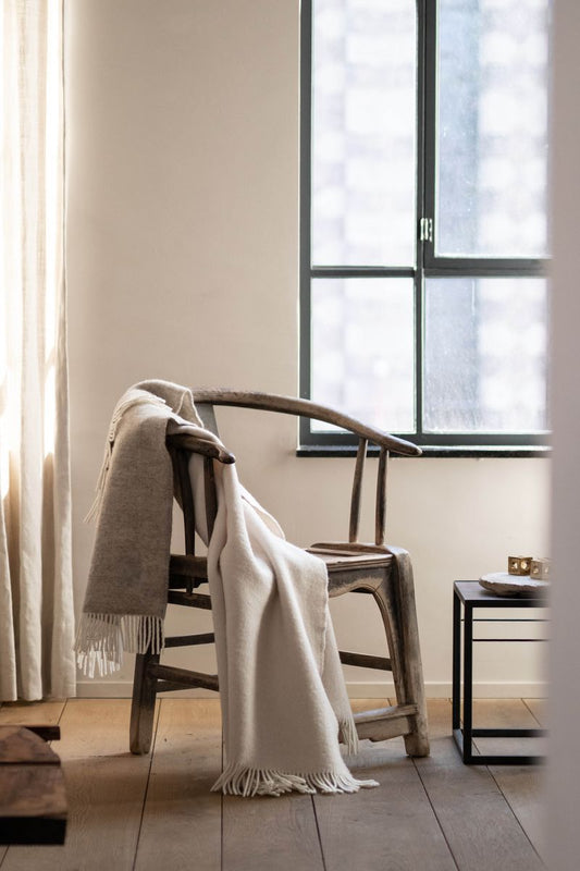 Forestry Wool Duo Wool Blanket - natural blanket woven from pure wool, draped over industrial chair.