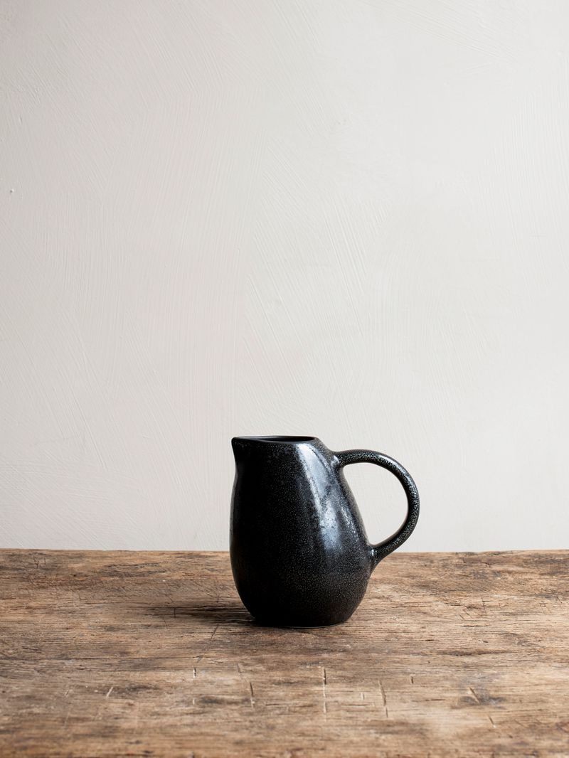 Kuro Pitcher by Jars Ceramistes on wooden table.