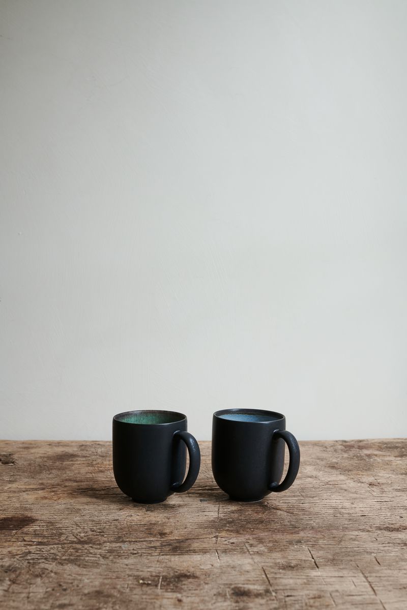 Two Ecorce Mugs by Jars Ceramistes on wooden table.
