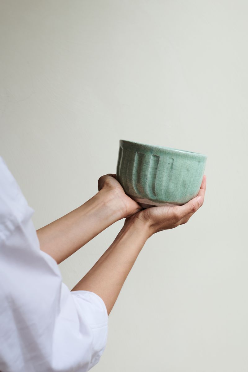Dashi Bowl Celadon by Jars Ceramistes. Being held in hands.