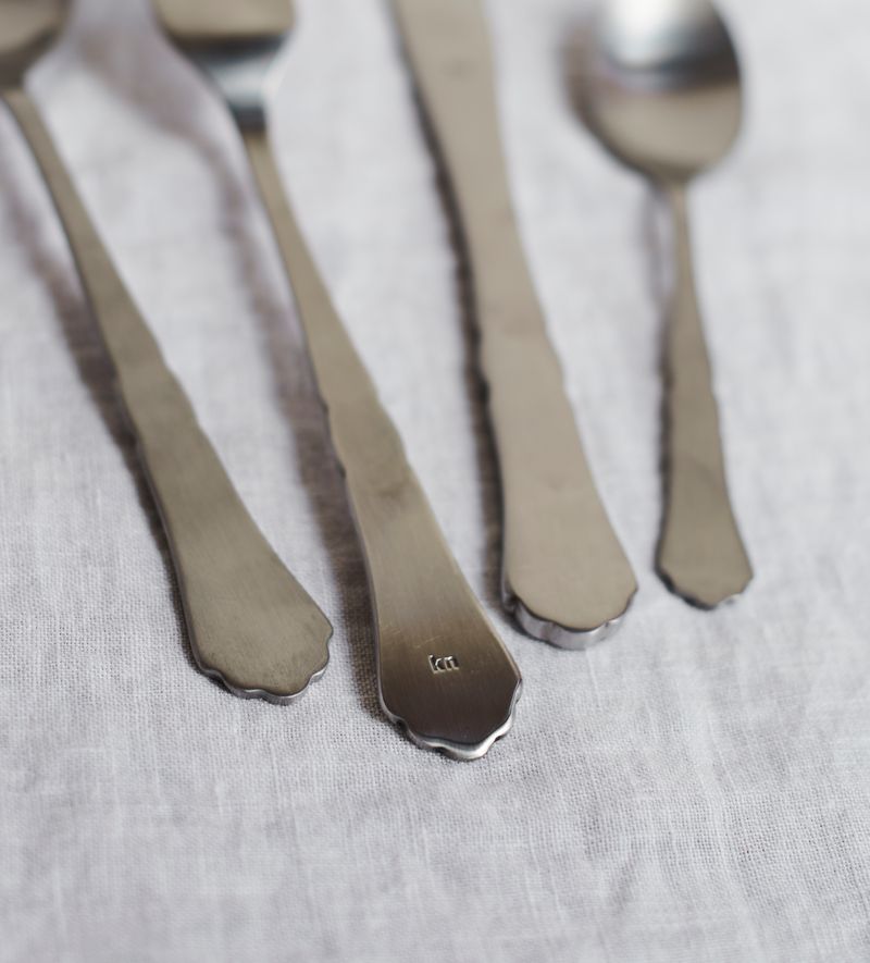 Detail shot of the KnIndustrie logo engraving in the back of the cutlery.