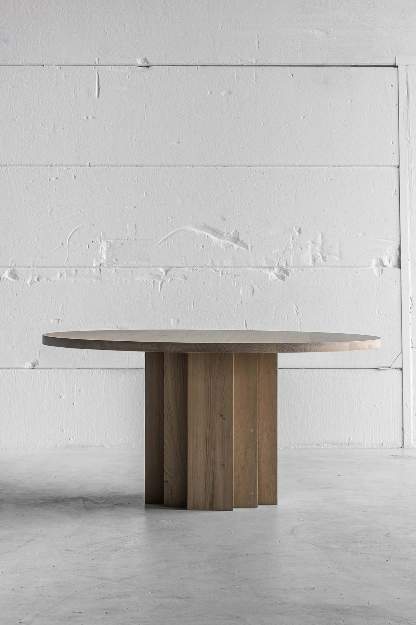 Handcrafted Round Brix Table by Heerenhuis. Round dining table made from Oak wood set in industrial white and light space.