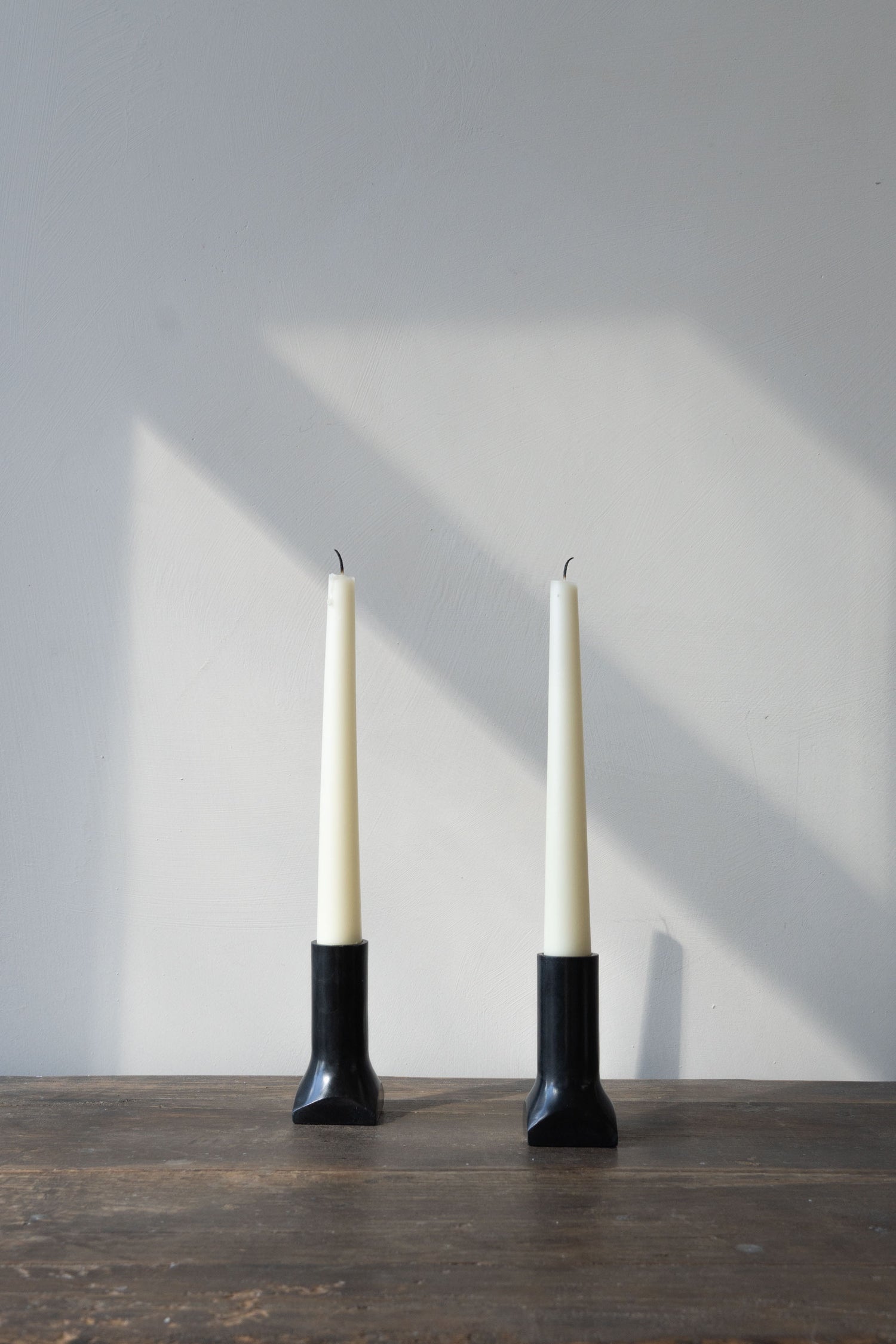 Soapstone candleholders by ENO Studio displayed on a rustic tabletop.