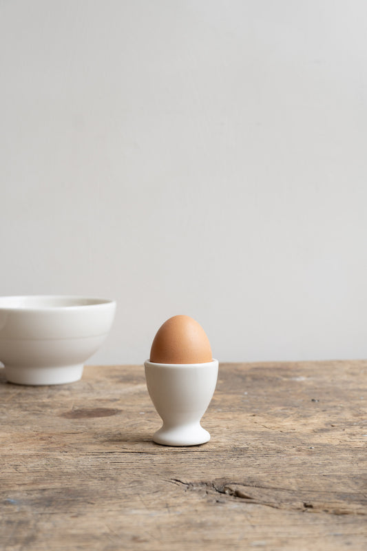 Ceramic Egg Cup Antibes White on wooden table.