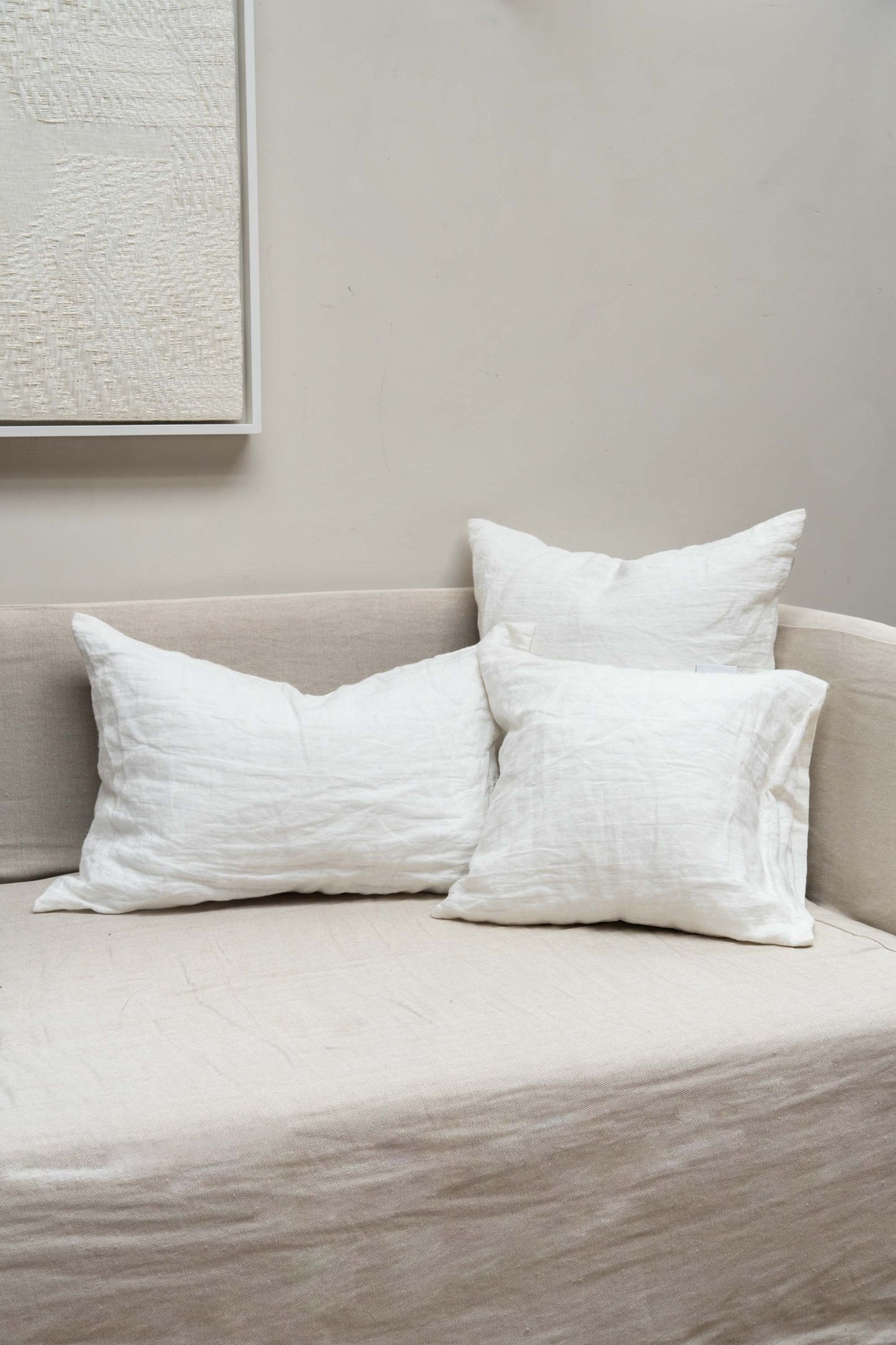 Off White Linen Cushions by Timeless Linen set on couch in a light and neutral interior at Enter The Loft.