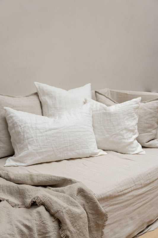 Linen Cushions by Timeless Linen in Off White set on couch in a light and neutral interior at Enter The Loft.