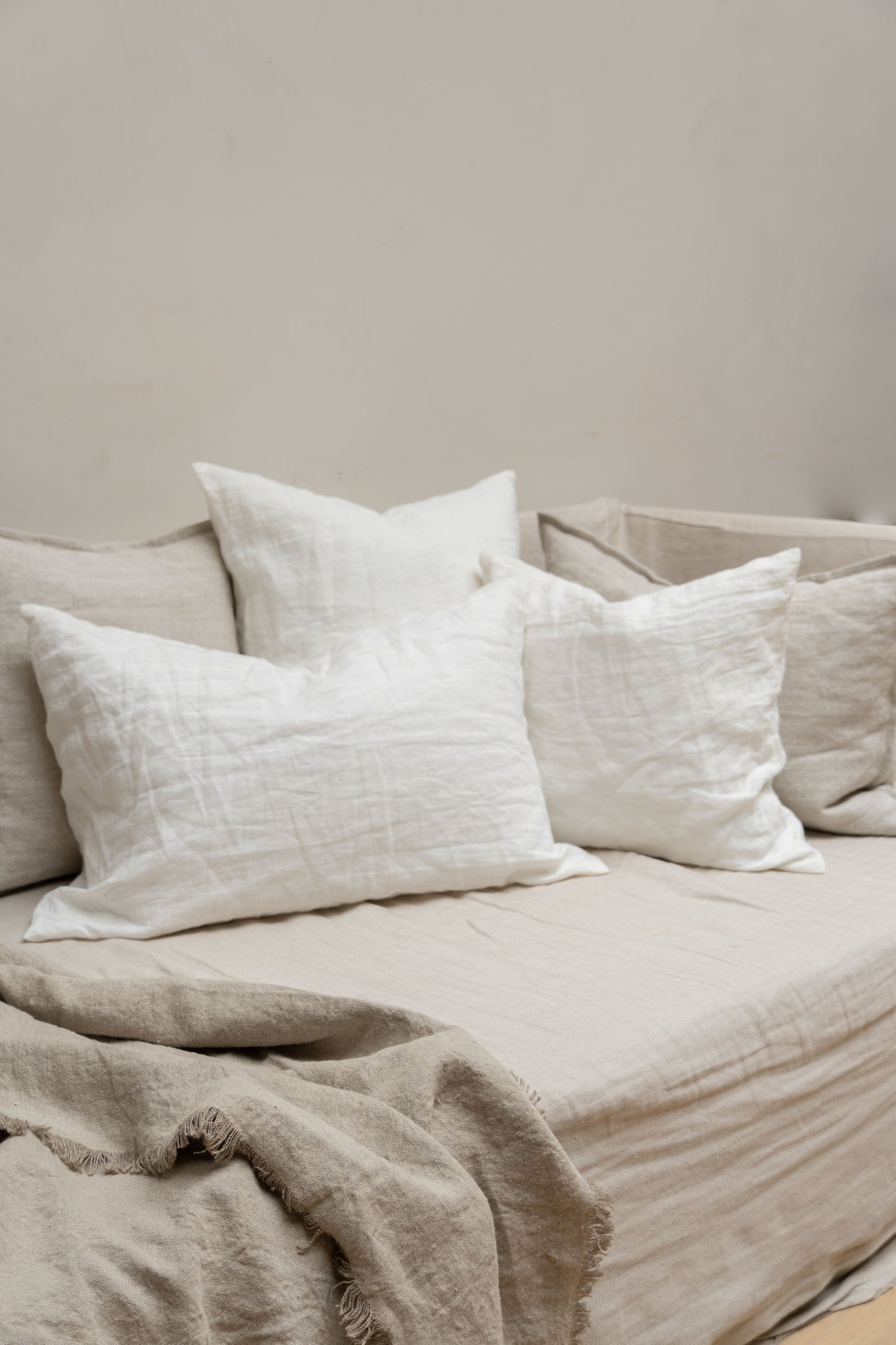 Linen Cushions by Timeless Linen in Off White set on couch in a light and neutral interior at Enter The Loft.