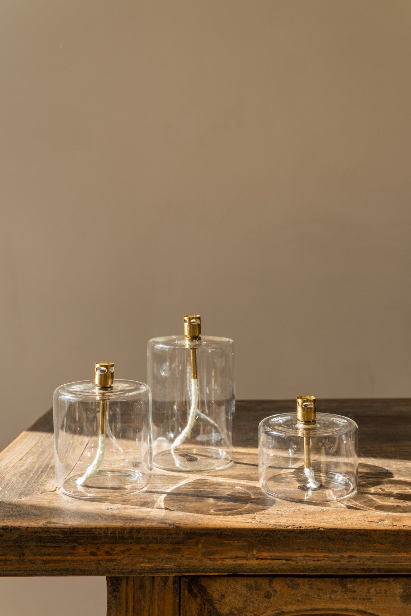 Set of three clear brass Cyl Oil Lamps by The Loft Selects.