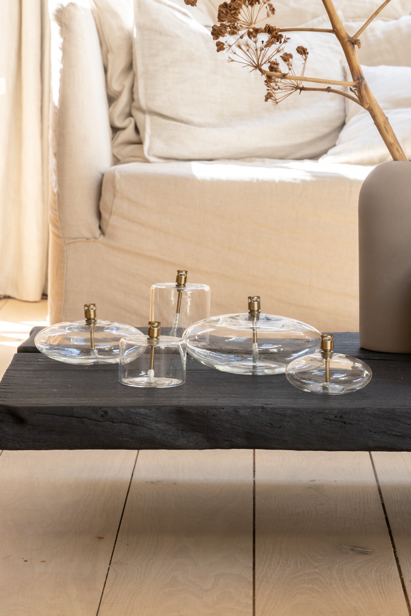 The Loft Selects Oil Lamps collection set on a black burned low coffee table in a light interior at Enter The Loft.