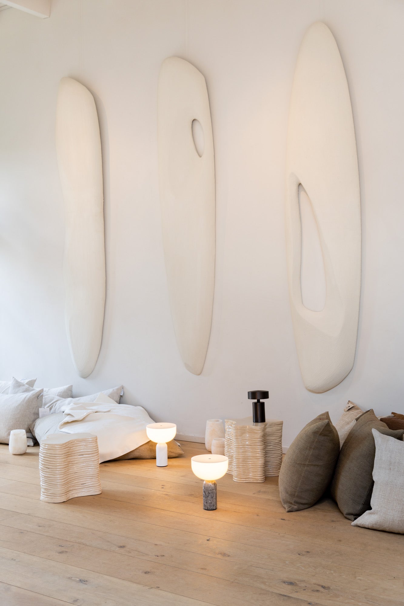 Kizu Portable Lamps used in a light and lofty interior setting with big wall art sculptures at Enter The Loft.