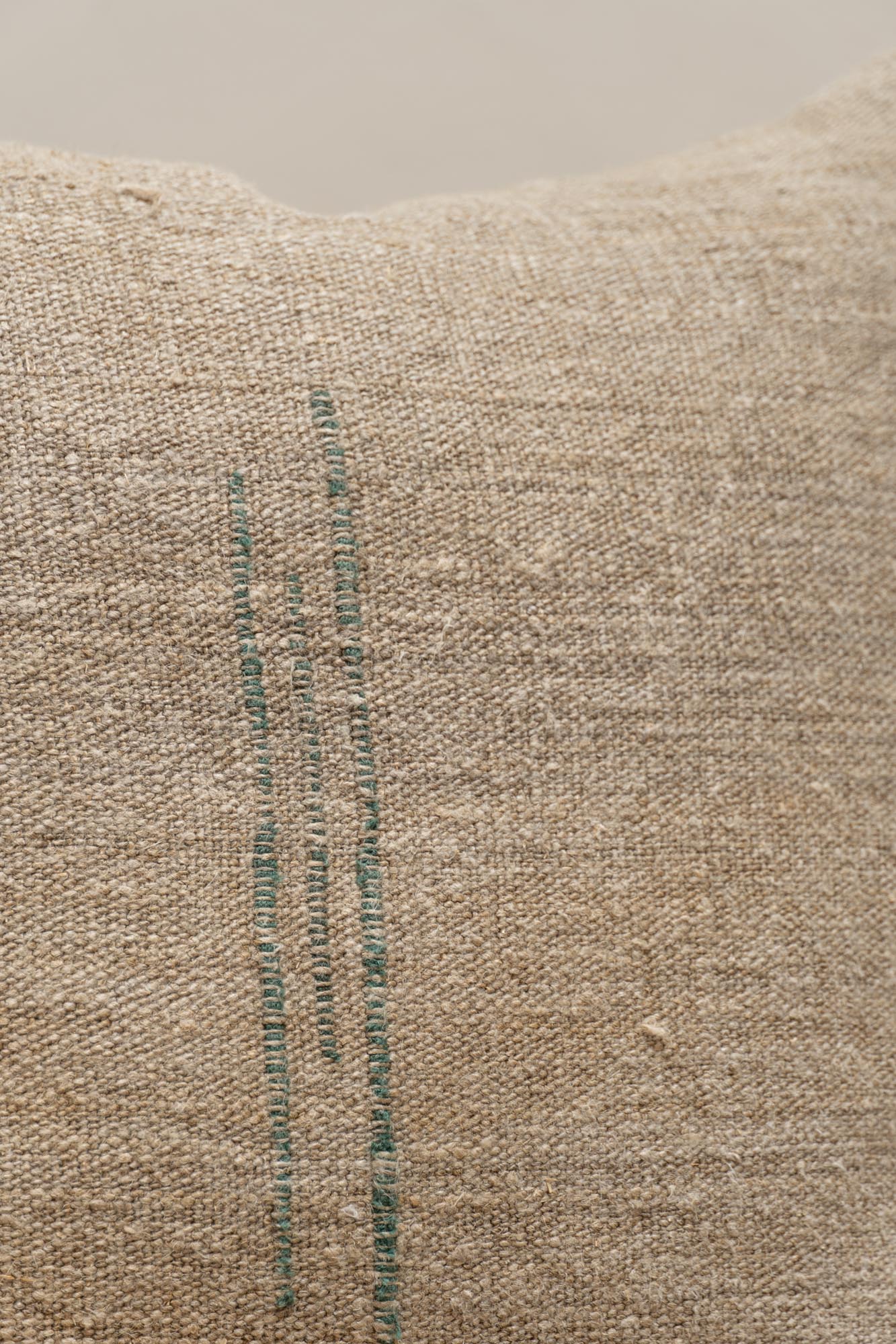 Close-up of the green threads detail in the antique hemp linen of the Vintage Collector's Cushion by Isabelle Yamamoto.