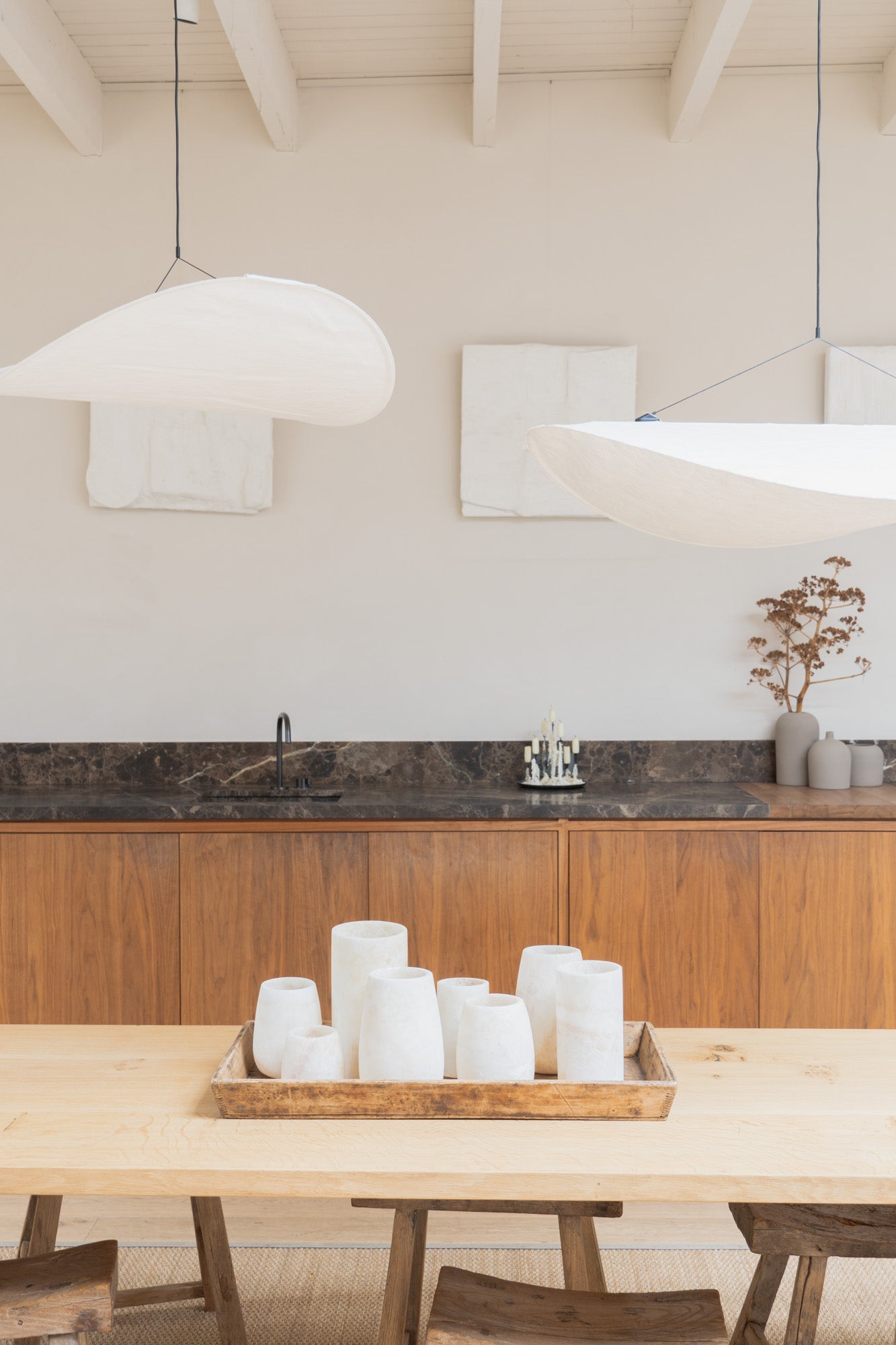 Light kitchen interior at Enter The Loft with multiple different sized Alabaster Tealights set on a wooden tray on the dining table.