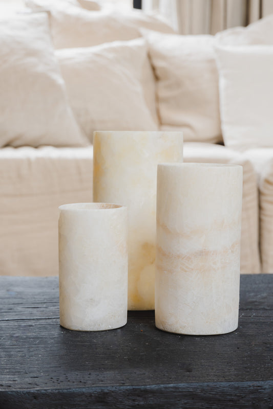 Three different sizes Alabaster Tealights by Nocturnals set on black wooden coffee table in living room at Enter The Loft.