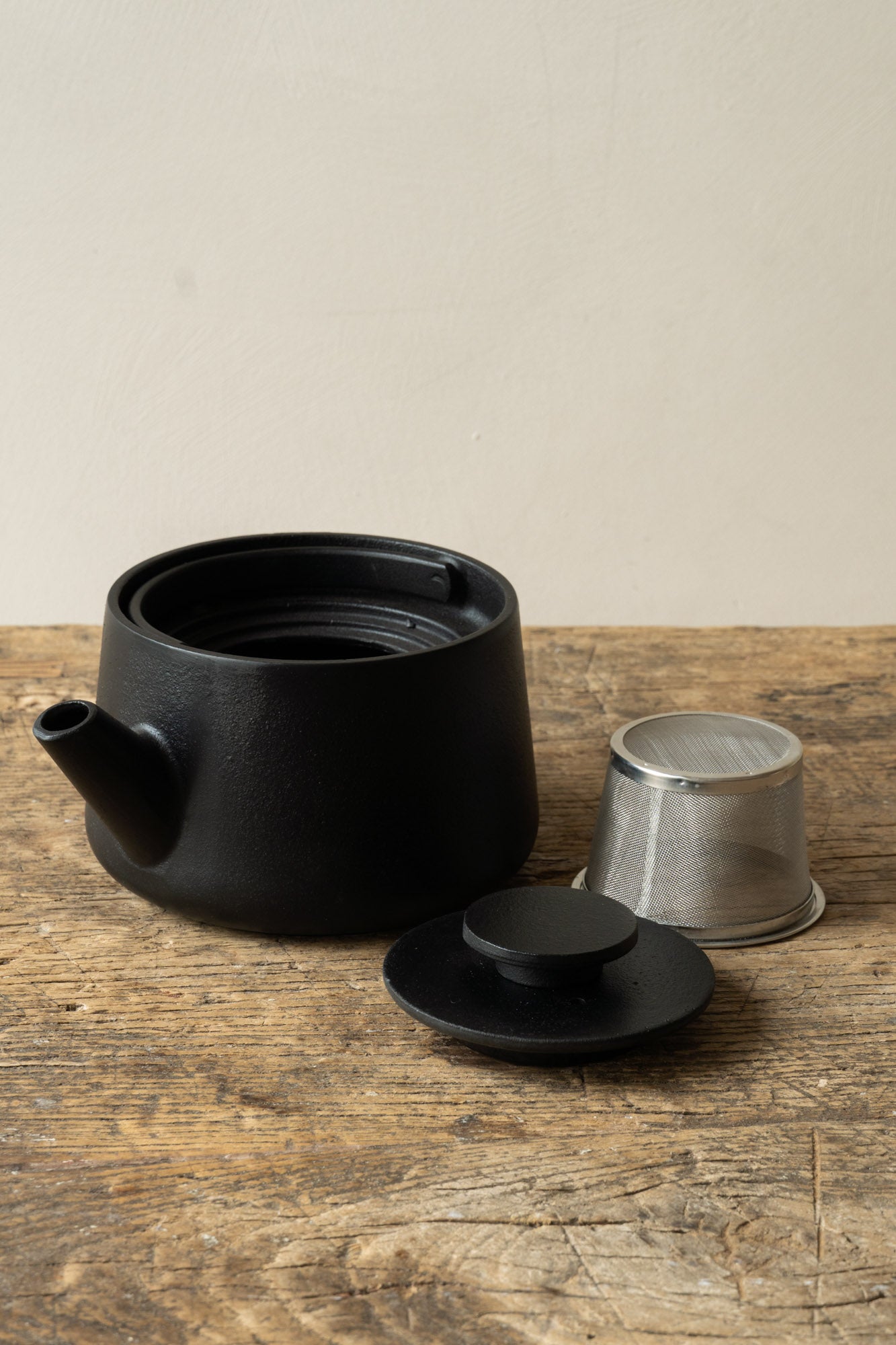 Inku Teapot Balck by Serax on wooden table.