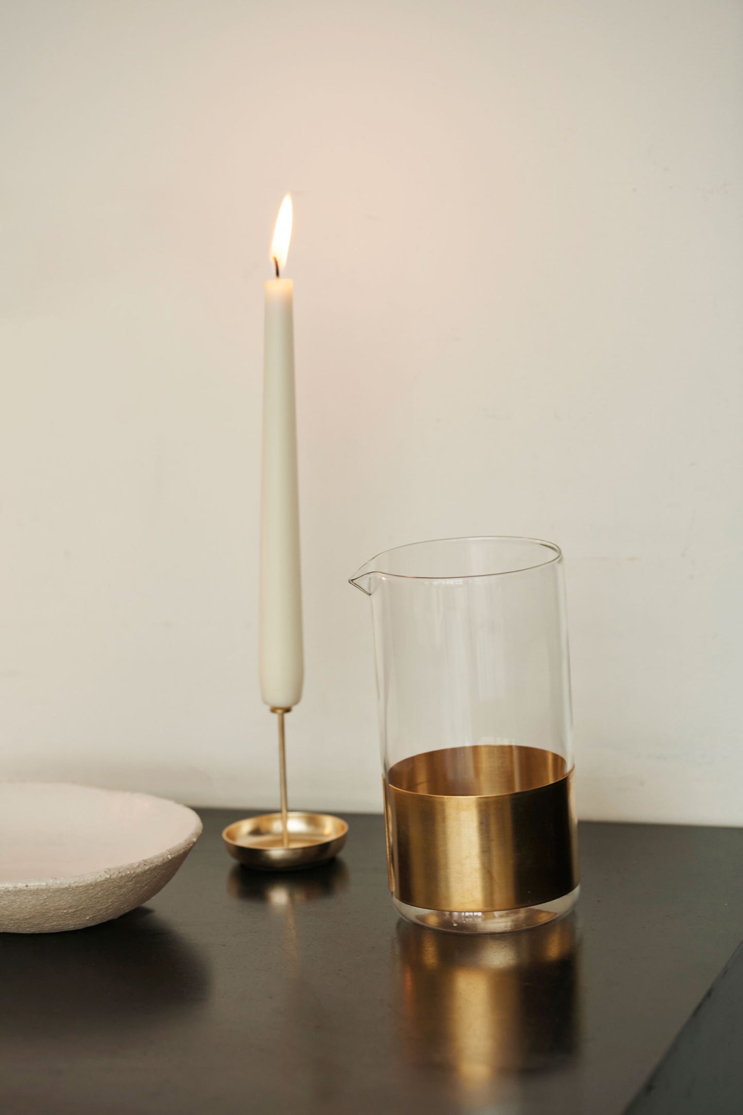 Serax Copper Alchemy Carafe, with lit candle in copper pin holder.