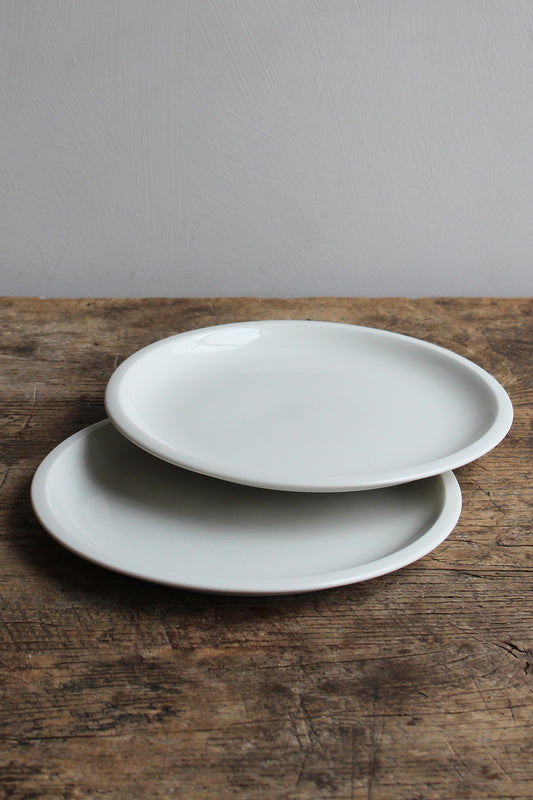 Two Antibes Plate White (24 cm) by Jars Ceramistes on wooden table at Enter The Loft.