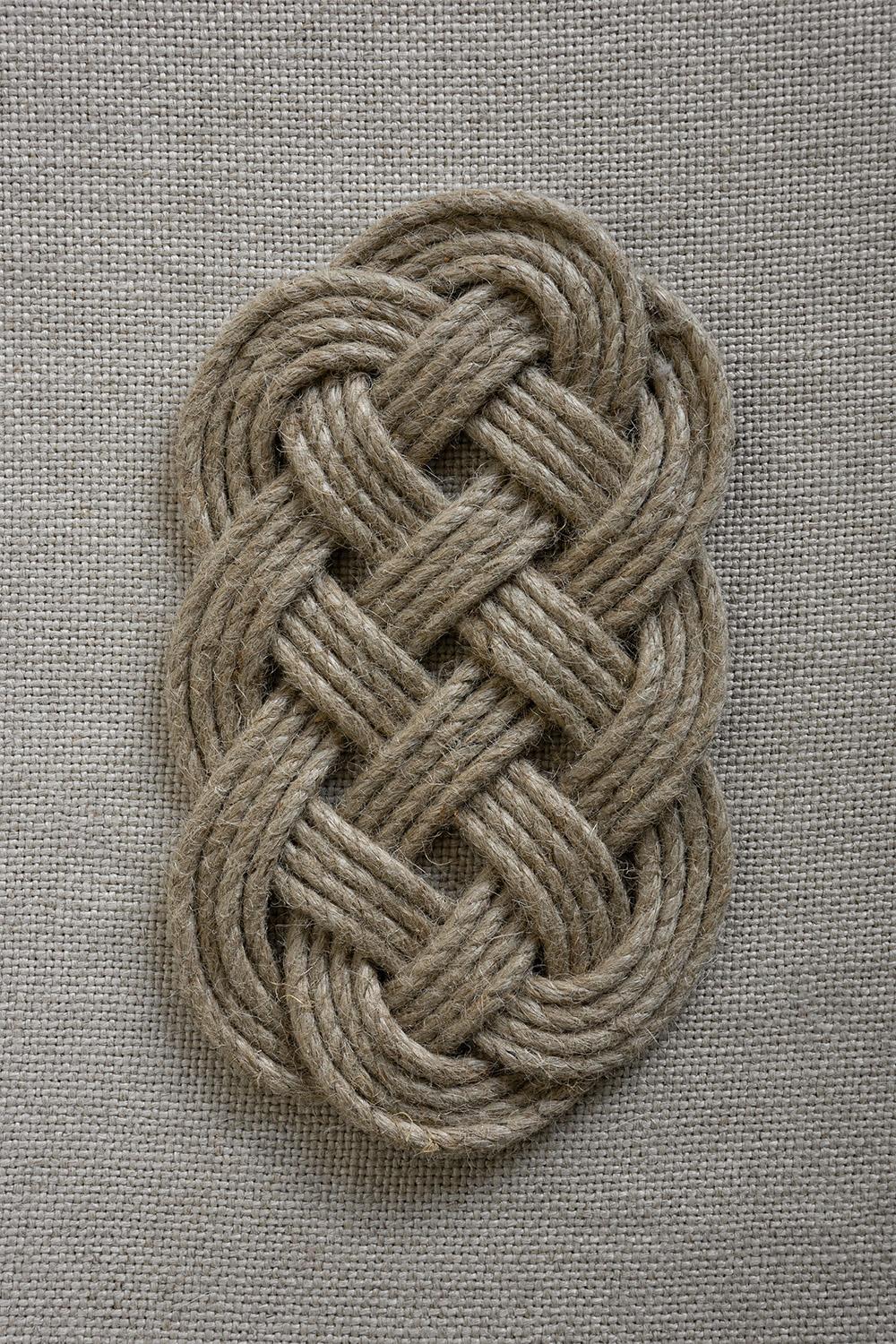 Braided trivet on neutral textile background