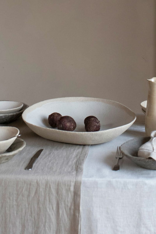 The Wabi Serving Plate by Jars Ceramistes on a natural and neutral table setting.