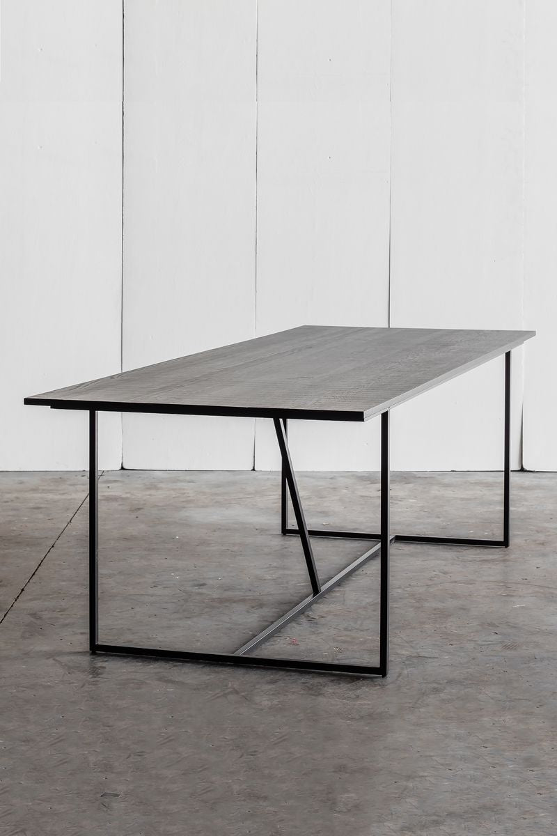 Mesa Nero Table by Heerenhuis made from Oak wood with a steel base.