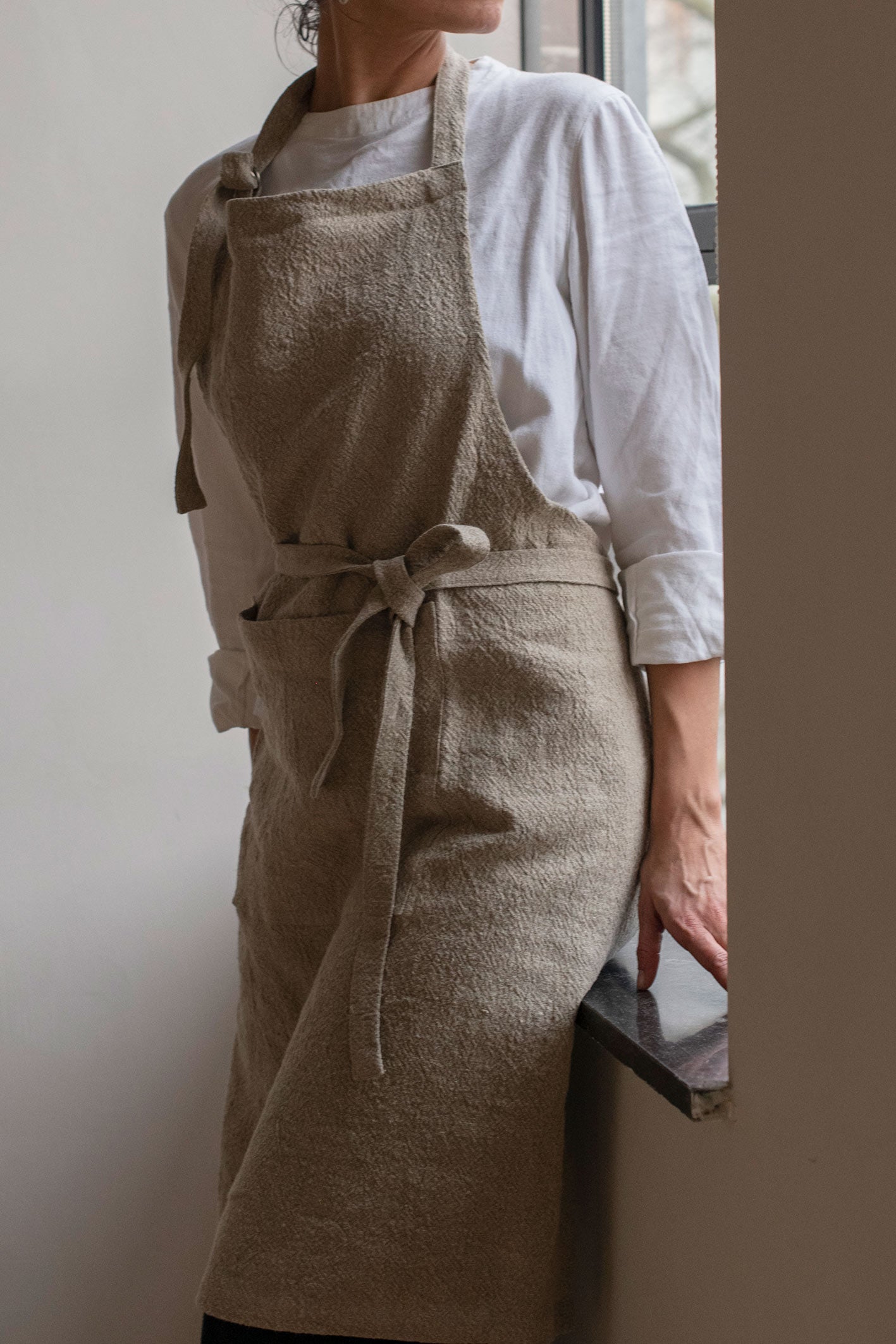 Timeless Linen Apron by Timeless Linen, worn by woman.