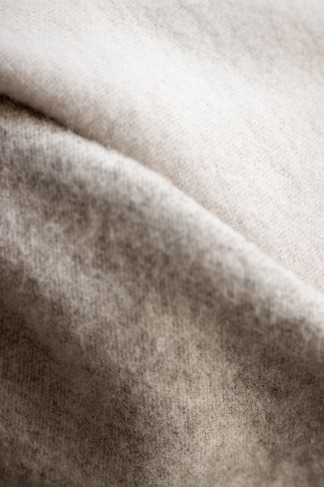 Close-up of the Duo Wool Blanket, showcasing its woven texture and fine craftsmanship. Made from pure wool, a natural material known for its warmth and comfort.