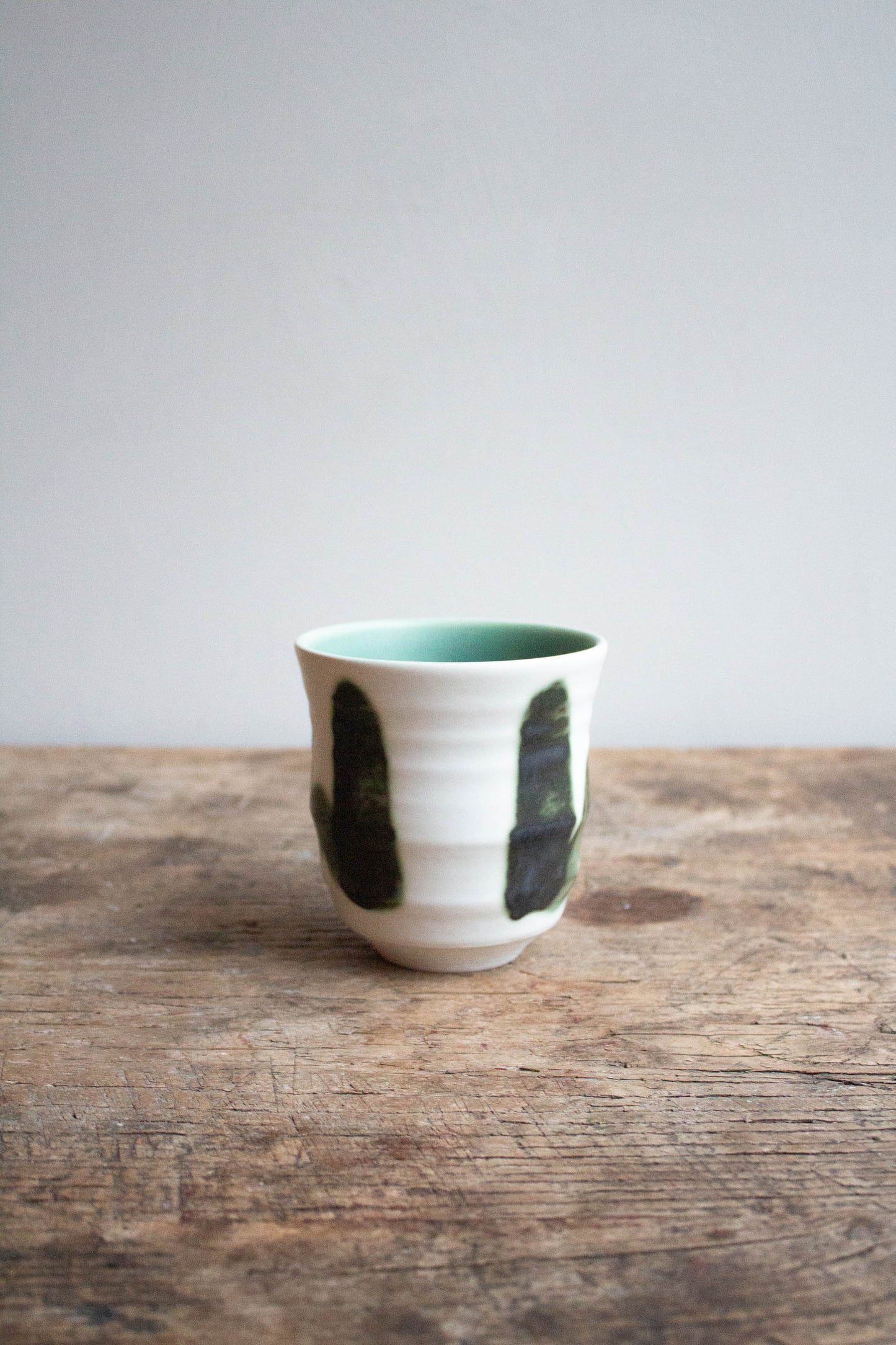 Dashi Mug Green on wooden table.