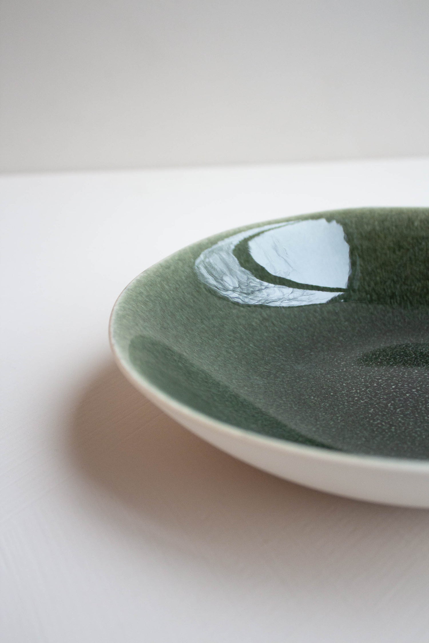 Close-up of the Maguelone Deep Plate Forest Green by Jars Ceramistes.