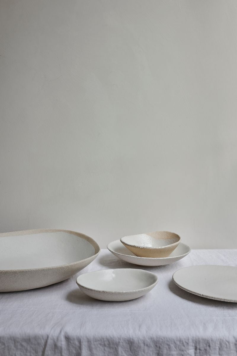Table with white linen cloth and selection of Wabi Plates by Jars Ceramistes.