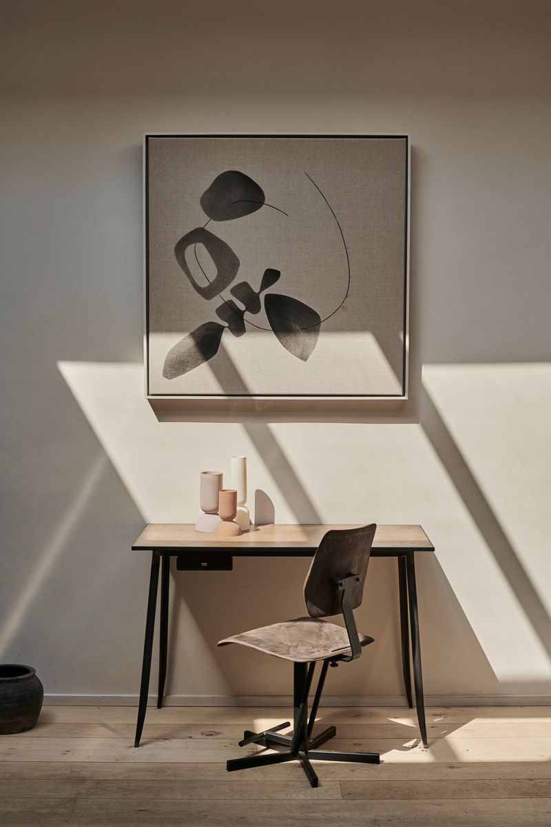 Kodak Chair in front of desk with abstract painting.