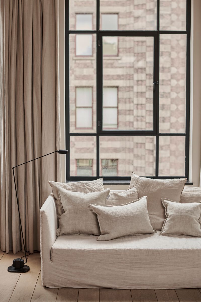 Coarse Linen cushions beige natural by Timeless Linen on couch in loft interior.